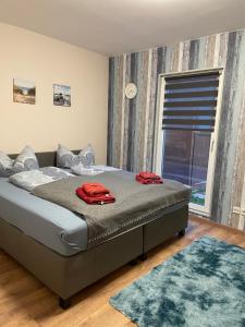 a bedroom with a bed with two red jackets on it at Ferienhaus in der Stienitzaue in Werneuchen