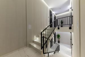 uma escadaria numa casa com paredes brancas e grades pretas em Luxury Apartments Laborca em Uzhhorod