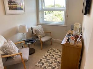 a living room with two chairs and a table at Camelot Guest House in Falmouth