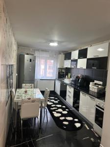 a kitchen with black and white cabinets and a table and chairs at Inchisa in Deva