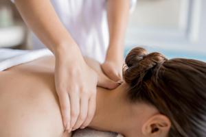 uma mulher a receber uma massagem às costas de um terapeuta em Huinid Bustillo Cabañas em San Carlos de Bariloche