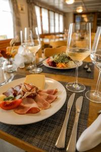 a table with a plate of food and glasses of wine at Hotel und Gasthaus Bad Gonten in Gonten +17 photos