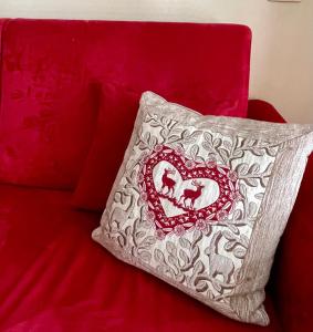 un oreiller avec un cœur sur un canapé rouge dans l'établissement Alpine Studio with Garage, à Breuil
