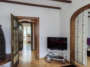 Pension & Appartments Landhaus Bettina Fulda في فولدا: غرفة معيشة مع تلفزيون بشاشة مسطحة ودراجة في الغرفة