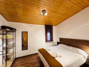 1 dormitorio con 1 cama grande y techo de madera en Apartamento Partara, en Aínsa