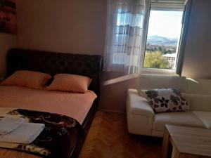 Habitación pequeña con sofá y ventana en Stankovic Apartman en Vranje