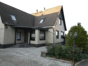 a brick house with a shingled roof at Ferienwohnung am Waldrand 