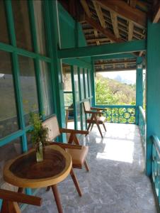 un porche de una casa con sillas y mesa en Vừng Homestay - Mộc Châu, en Mộc Châu