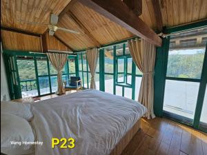 1 dormitorio con 1 cama en una habitación con ventanas en Vừng Homestay - Mộc Châu en Mộc Châu