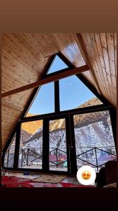 Kurmenty的住宿－Kolsay Village，配有木制天花板的客房内的大窗户