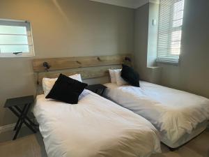 two twin beds in a room with a window at Port St Francis - QuarterDeck in St Francis Bay