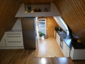 a kitchen with white cabinets and a stainless steel refrigerator at Ferienwohnung am Waldrand 