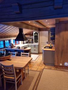 uma cozinha com uma mesa de madeira e uma sala de jantar em Stor og flott hytte med fantastisk utsikt em Geilo