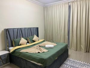 Un dormitorio con una cama con sábanas verdes y una ventana en 2Bedroom Palm Jumeirah luxury Stay At Golden Mile 10, en Dubái