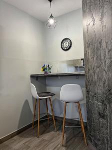 uma cozinha com duas cadeiras e um balcão e um relógio em — Premium apartment — em Ivano-Frankivsʼk