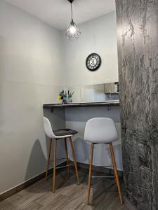 a kitchen with two chairs and a counter and a clock at — Premium apartment — in Ivano-Frankivsʼk