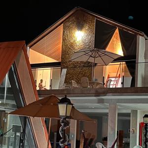 Villa Suíça, Chalé Mezanino في تيانغوا: منزل مع فناء مع مظلة