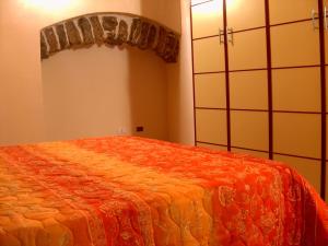 a bedroom with a large bed with an orange blanket at Casale Vacanze in Siculiana