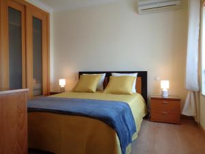 a bedroom with a large bed with two lamps on it at Apartamento Arade Mar in Portimão