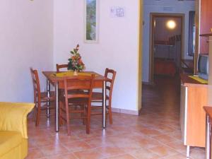 a dining room with a table with chairs and a kitchen at Casale Vacanze in Siculiana