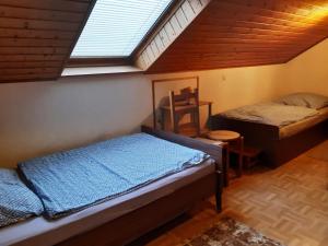 a attic room with two beds and a window at Ferienwohnung Breuer 