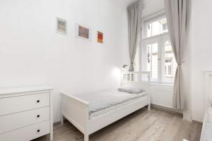 a white bedroom with a bed and a window at Perfect Day 3 -3 bedr, 2 bathrooms in Budapest