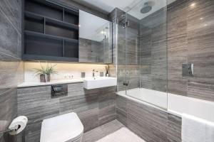 een badkamer met een toilet, een wastafel en een bad bij Chic 1BR Flat in Elephant and Castle in Londen