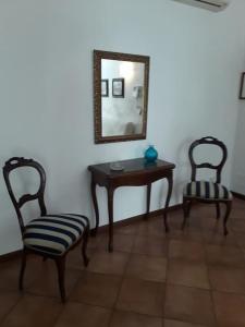 Zimmer mit 2 Stühlen, einem Tisch und einem Spiegel in der Unterkunft Appartamento al Sole in Vicenza