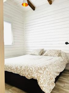 a bedroom with a bed with white sheets and a window at Eco alojamiento la Cartuja de Talamanca in Talamanca de Jarama