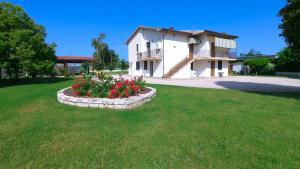 a house with a flower bed in the yard at Agriturismo Le Radici in Borgo Montenero