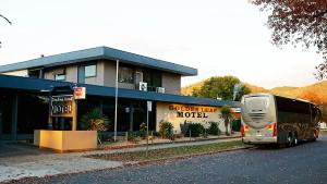 a tour bus parked in front of a motel at Golden Leaf Motel in Myrtleford