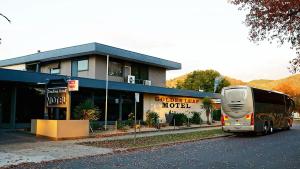 un autobús turístico estacionado frente a un motel en Golden Leaf Motel, en Myrtleford