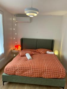 a bedroom with a bed with two pillows on it at Orange & Art in Clermont-Ferrand