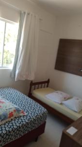 2 camas en una habitación pequeña con ventana en Duda lia, en Penha