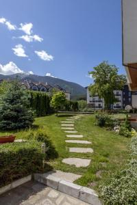 a stone path in a grassy yard with buildings at One Bedroom Apartment Pirin Lodge in Bansko