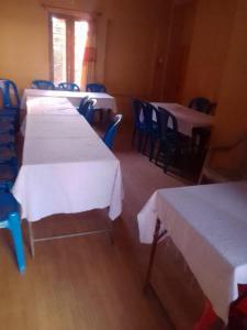 a room with four tables and blue chairs at Hotel Pacific Pokhara in Pokhara