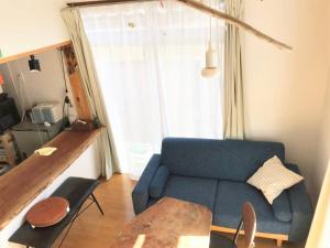 salon z niebieską kanapą i stołem w obiekcie Tsushima White House w mieście Tsushima