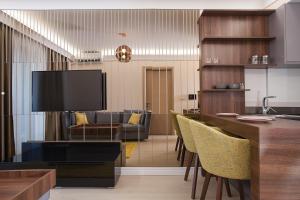 a living room with a tv and a table and chairs at GM SkyView Luxury Flatiron apartment Skopje in Skopje