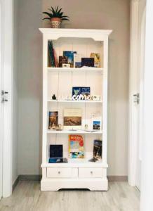 una estantería blanca con libros. en ALÌKA apartment, en Agrigento