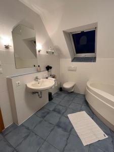 La salle de bains blanche est pourvue d'un lavabo et de toilettes. dans l'établissement FeWo 1 an der historischen Bahnlinie, à Leutkirch im Allgäu
