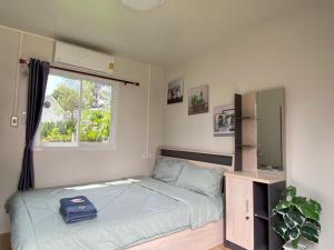 a small bedroom with a bed and a window at วิวเขื่อน โฮมสเตย์ 