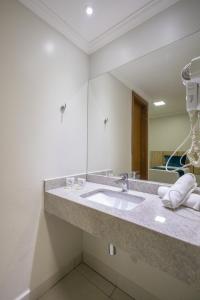 W łazience znajduje się umywalka i lustro. w obiekcie HOT SPRINGS HOTEL - BVTUR w mieście Caldas Novas