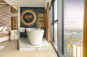een badkamer met een bad en een groot raam bij Hanza Tower GOLD-21 in Szczecin
