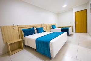 sypialnia z 2 łóżkami i niebieskimi poduszkami w obiekcie HOT SPRINGS HOTEL - BVTUR w mieście Caldas Novas