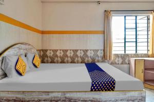 a bedroom with a large bed with a window at OYO Torna Lodge in Pune