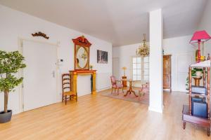 a living room with a table and a grandfather clock at Lovely apartment with exceptional terrace in Bordeaux