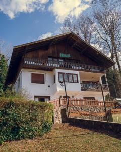 a house with a wooden roof and a fence at Hostel Planeta Cumbrecita in La Cumbrecita