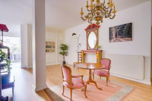 una sala da pranzo con tavolo, sedie e lampadario pendente di Lovely apartment with exceptional terrace a Bordeaux