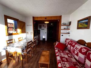 a living room with a table and a couch at Studio Les Saisies, 1 pièce, 4 personnes - FR-1-293-193 in Les Saisies