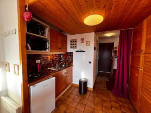 a small kitchen with wooden cabinets and a sink at Studio Les Saisies, 1 pièce, 4 personnes - FR-1-293-193 in Les Saisies